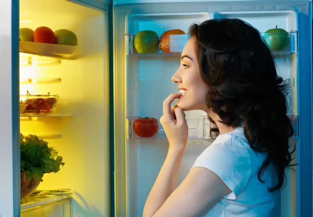 Το κορίτσι κοιτάζει στο ψυγείο κατά τη γρήγορη απώλεια βάρους